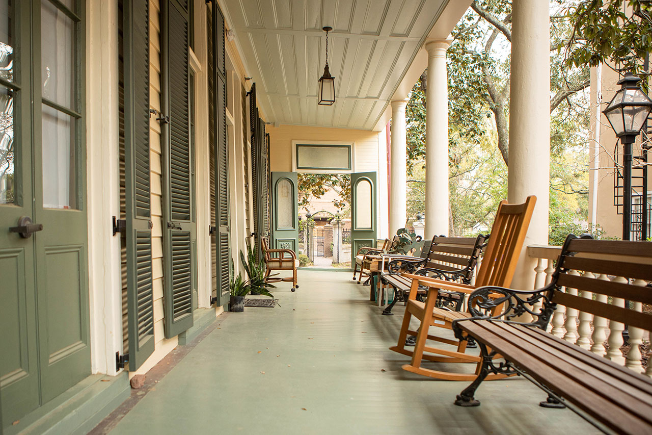 benches and rocking chairs on a porch