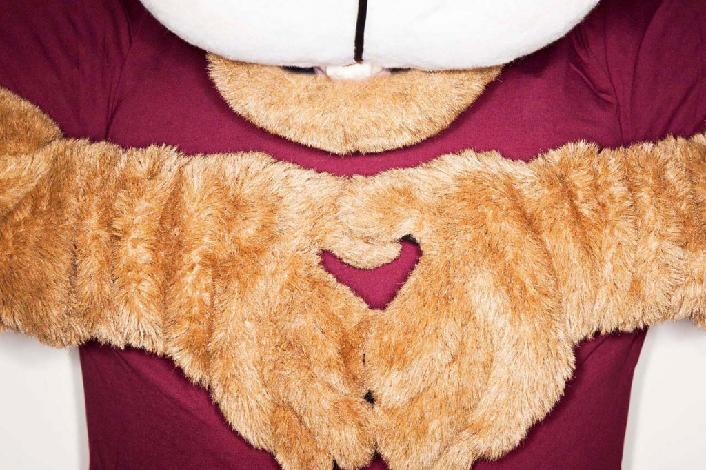 Clyde the cougar makes a heart shape with his hands