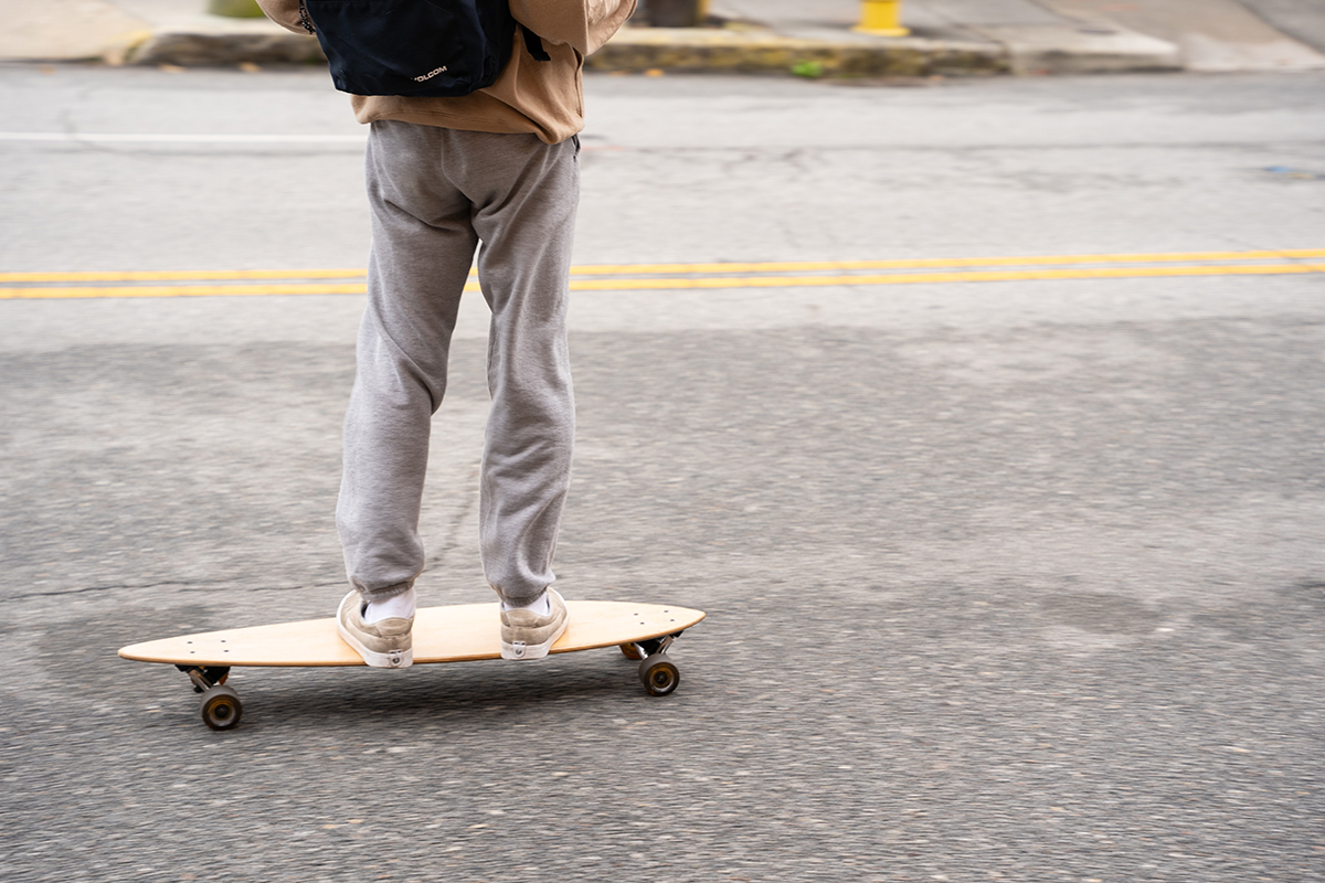 A CofC student skateboards to class.