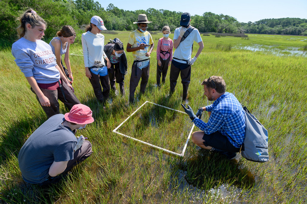 chris freeman with students in marsh