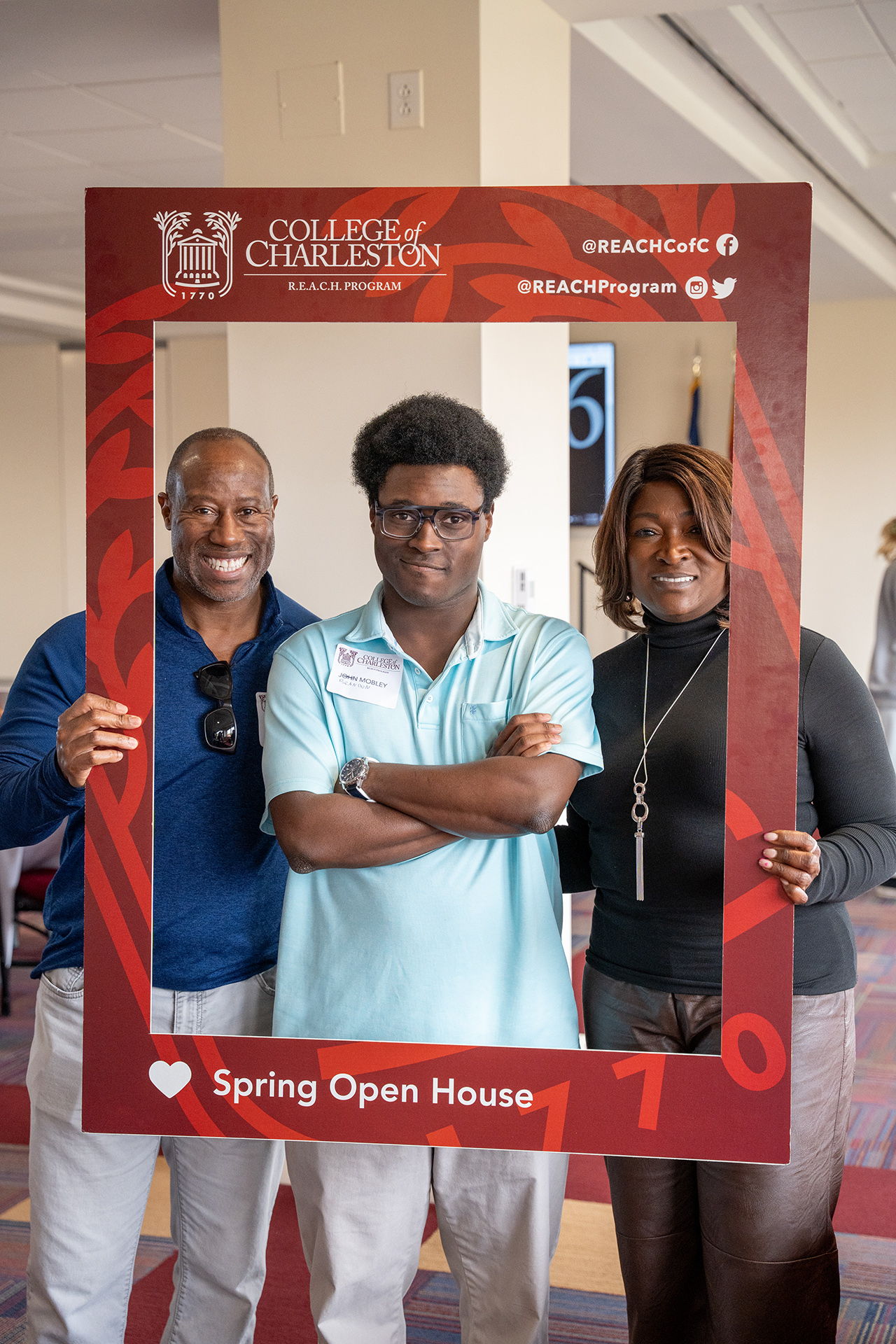 families pose in frame at REACH open house 