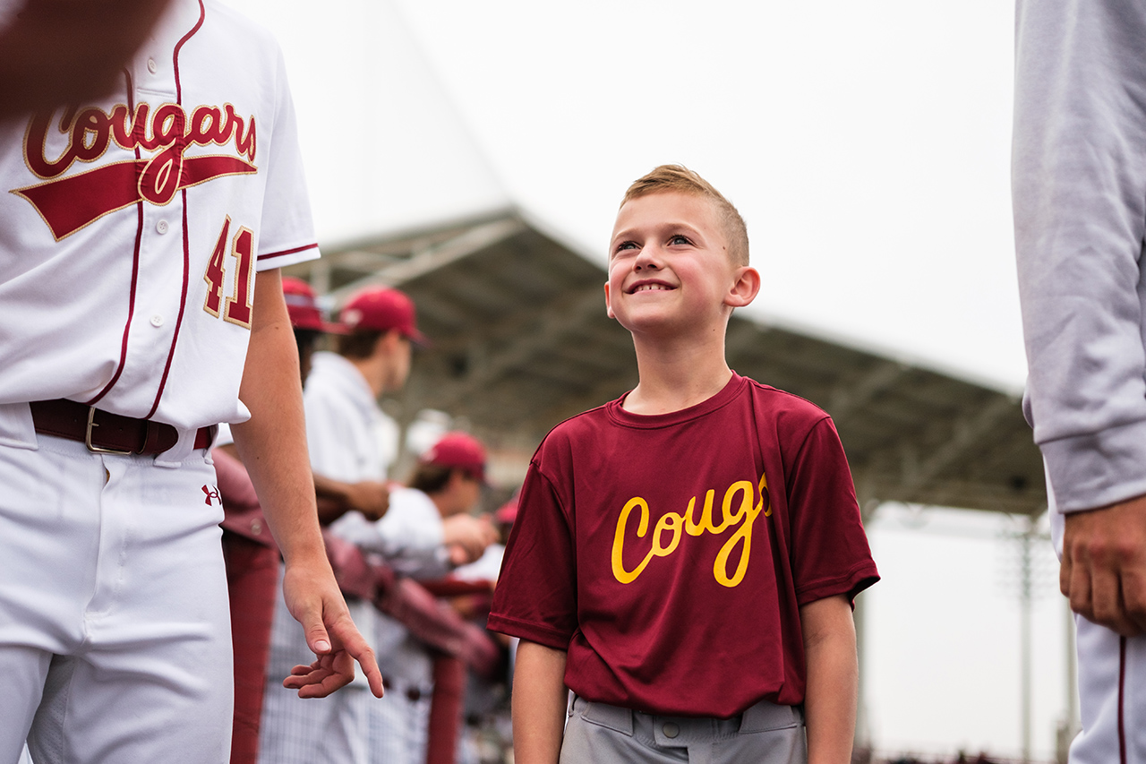 Ball boy looks up to College Baseball Players