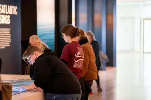 A group of students viewing artifacts inside a museum. 