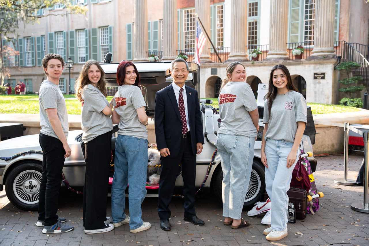 President Hsu poses withe the delorean car and students for CofC day