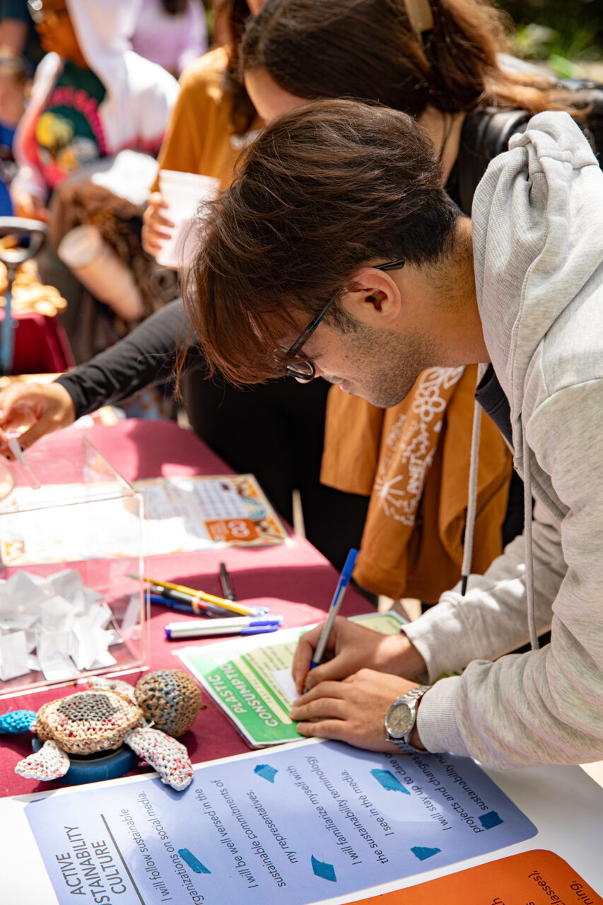 CofC student interacting with Honors Engaged booth at Sustainability Fair. 