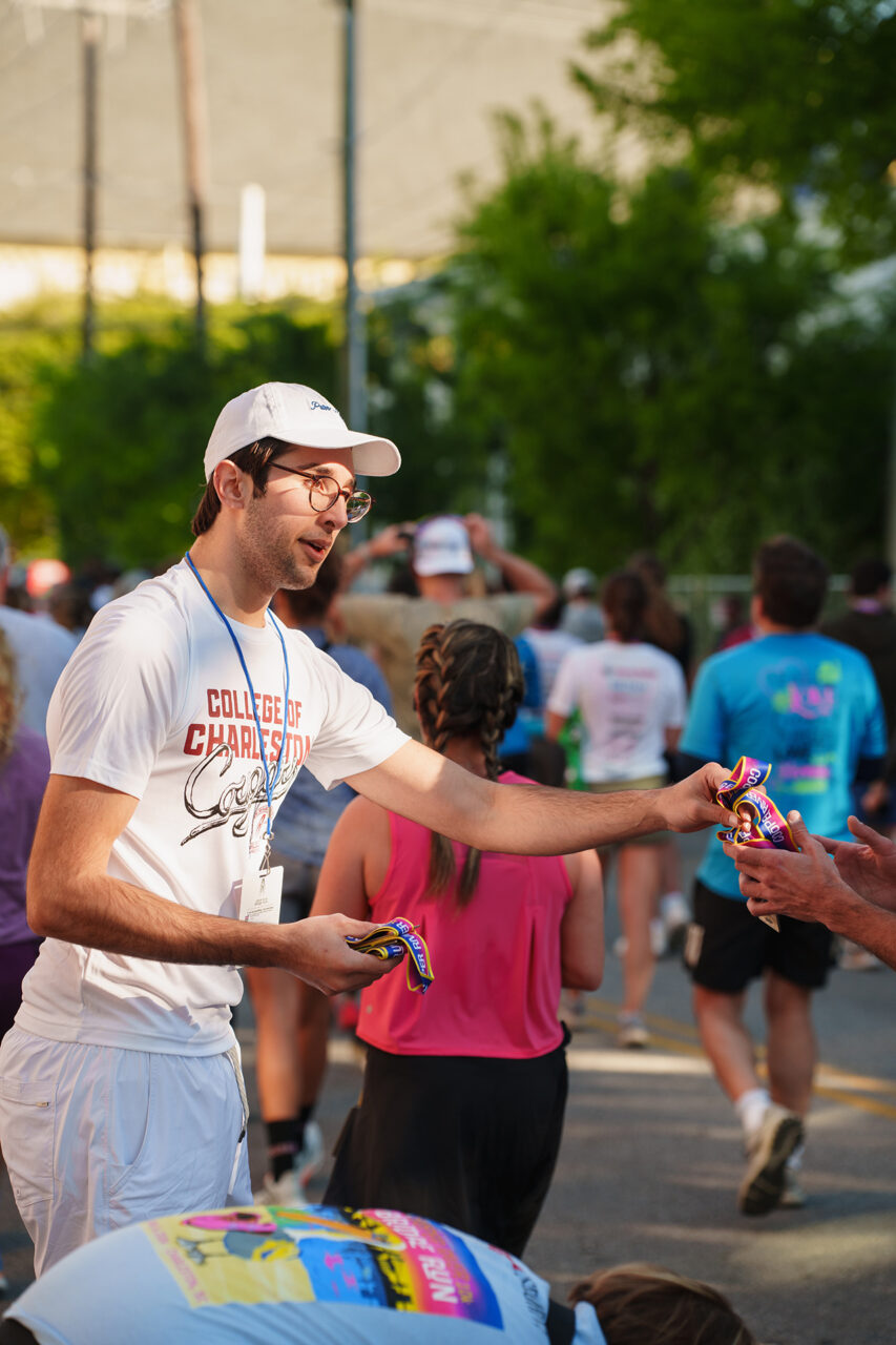 handing out medals at the finish line