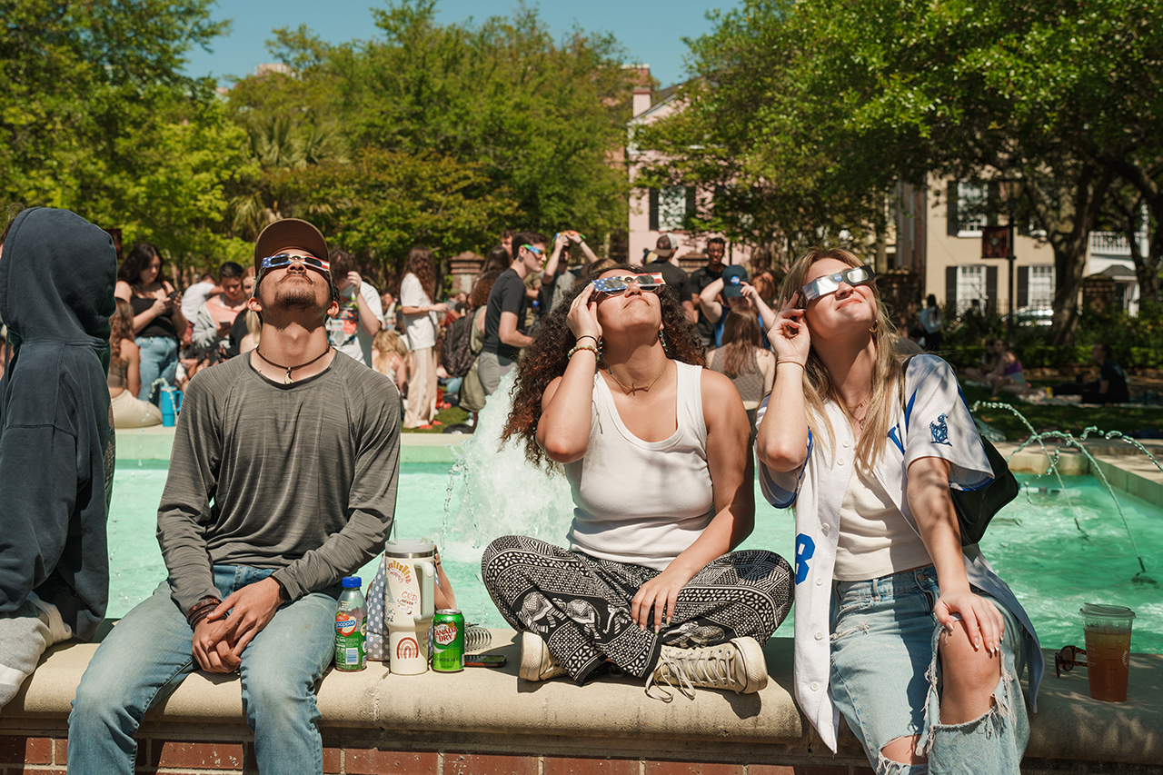 Students gather on Rivers Green looking up at the partial Solar Eclipse 