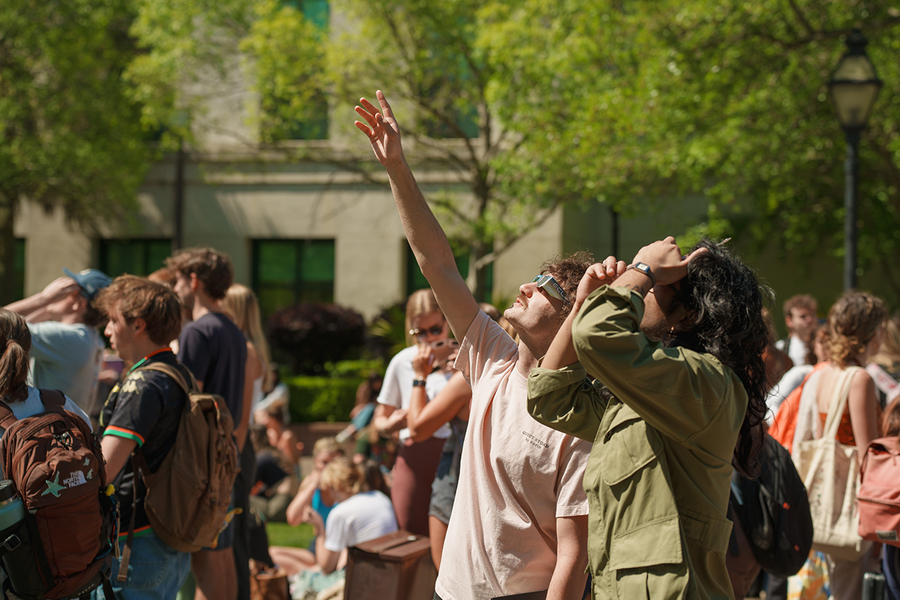 Students gather on Rivers Green looking up at the partial Solar Eclipse 