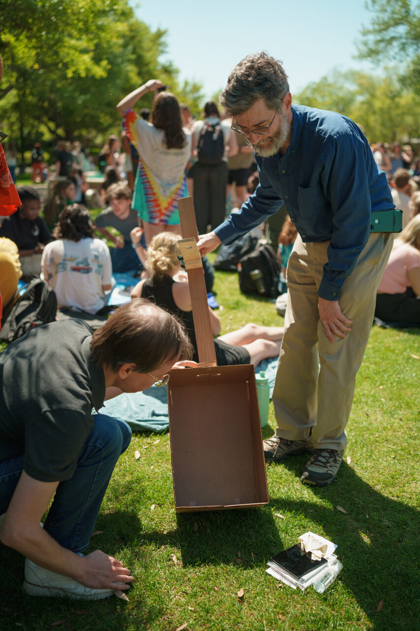 Students gather on Rivers Green looking up at the partial Solar Eclipse 