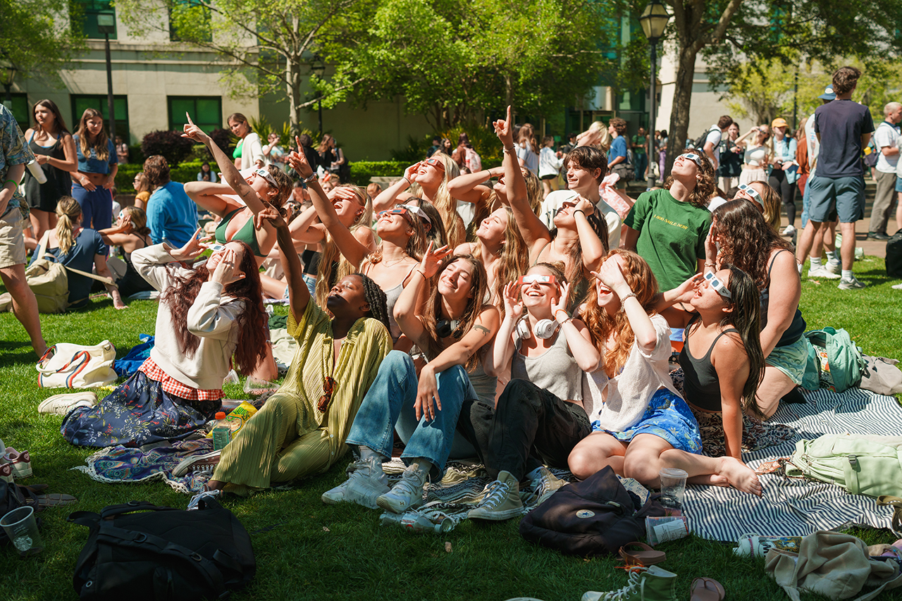 Students gather on Rivers Green looking up at the partial Solar Eclipse 