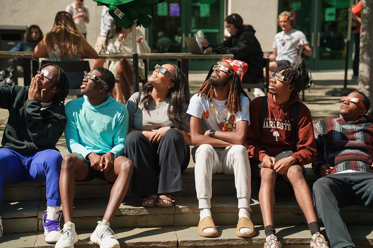 Students gather on Rivers Green looking up at the partial Solar Eclipse 