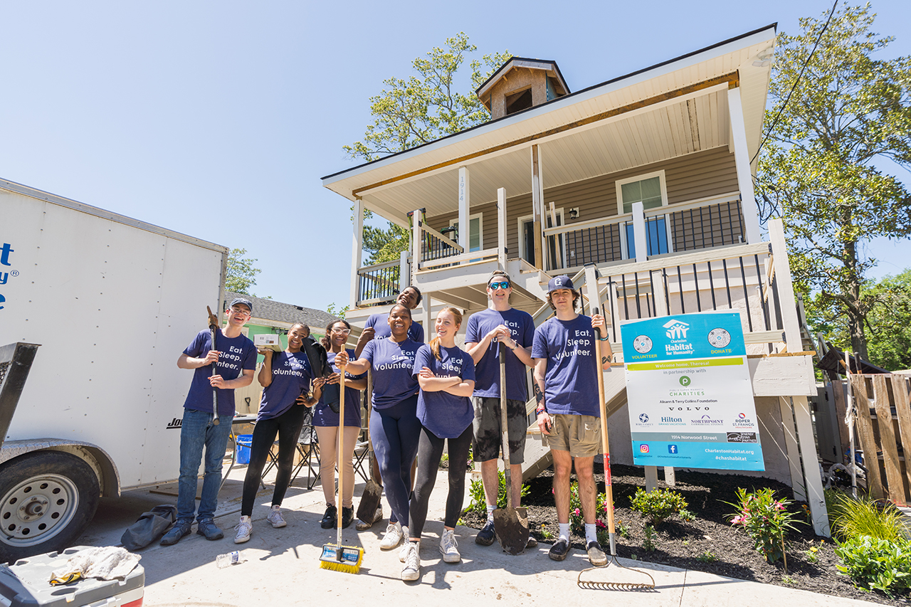 students pose by a home for Habitat For Humanity in Charleston