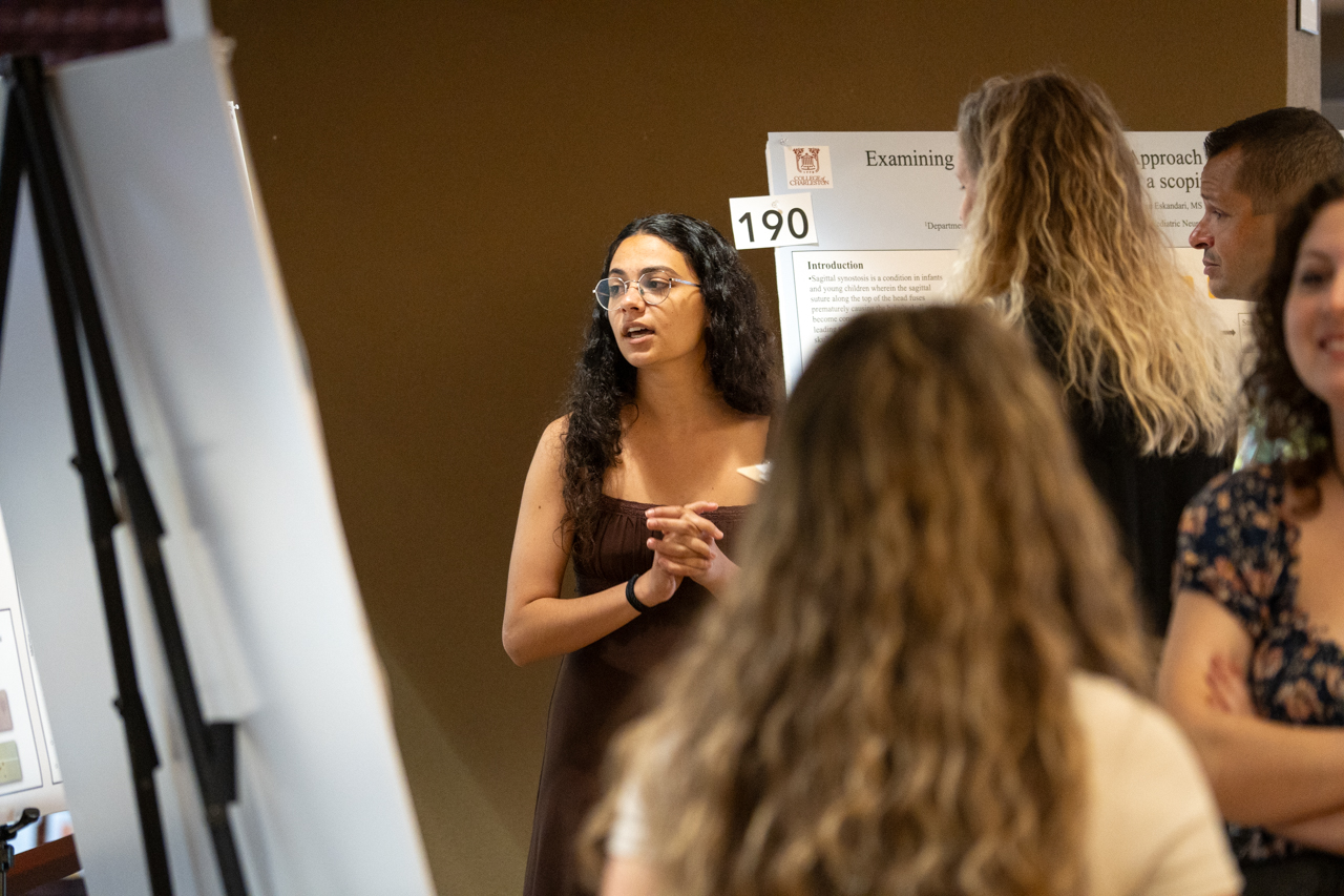 Student discusses research poster at 2024 EXPO