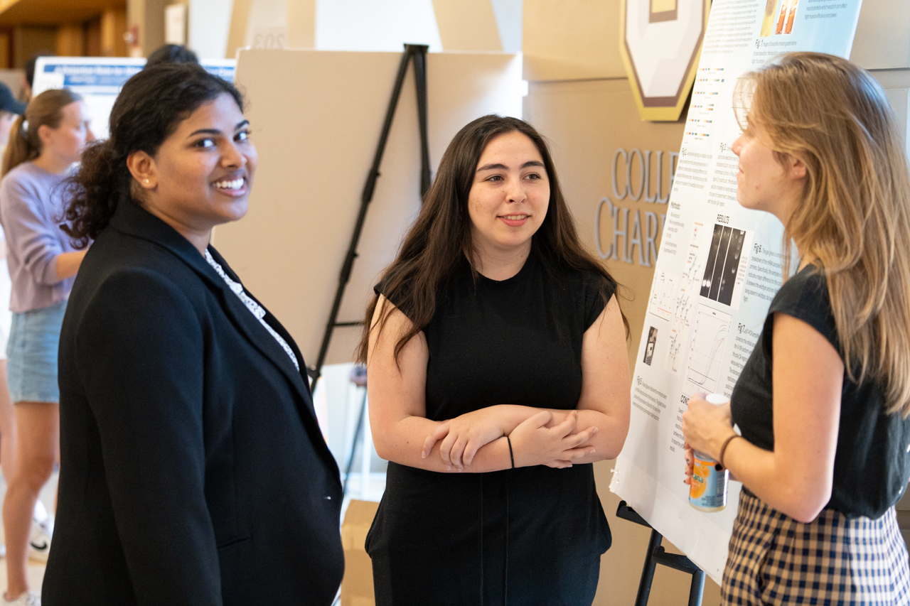 Students talk about research posters at EXPO