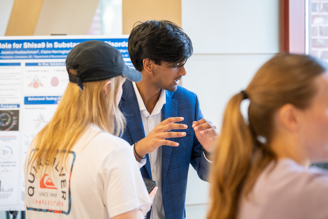 Student discusses research with other students at 2024 EXPO