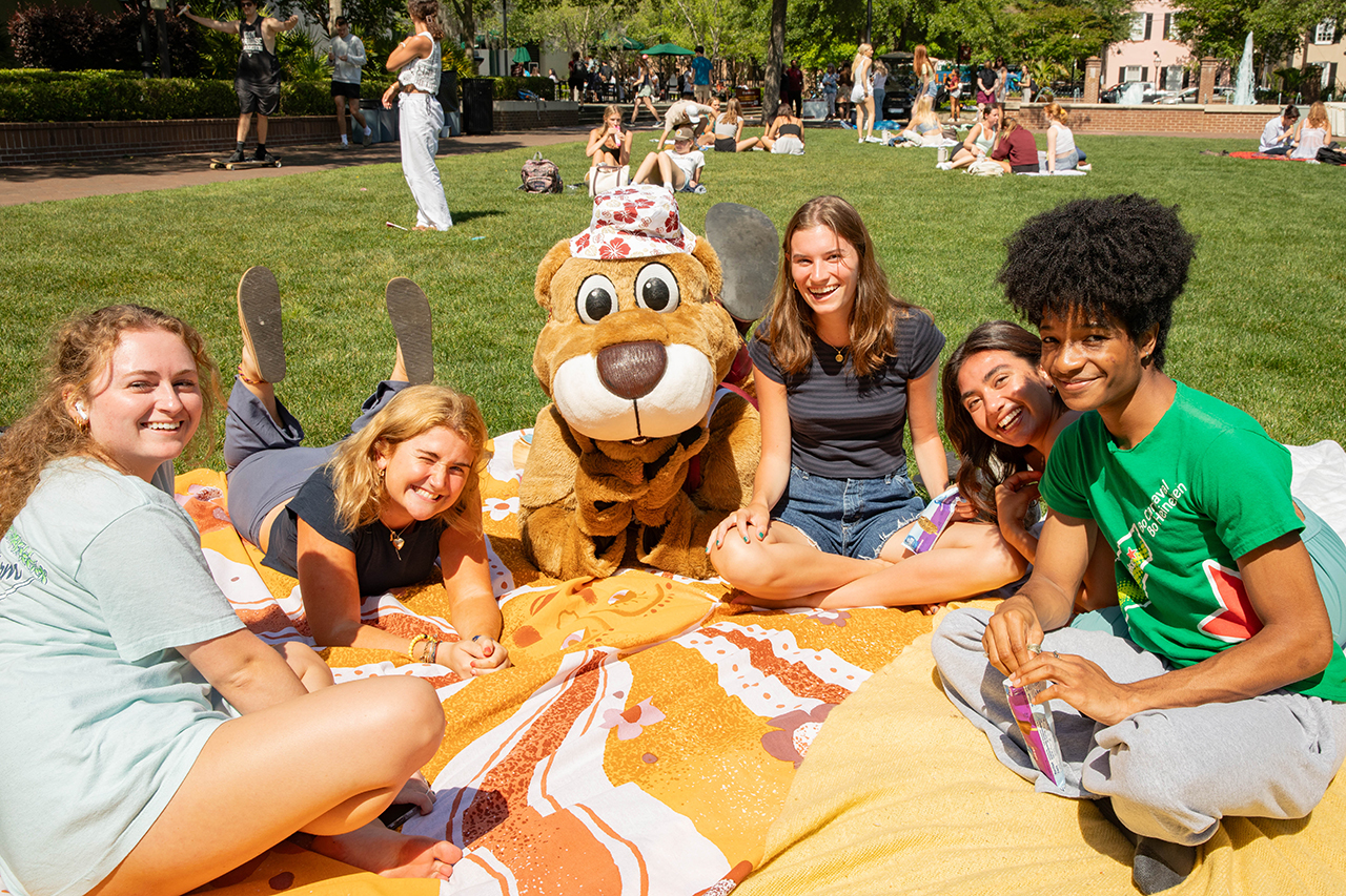 Students sit on the lawn with Clyde during Scoops with Hsu.