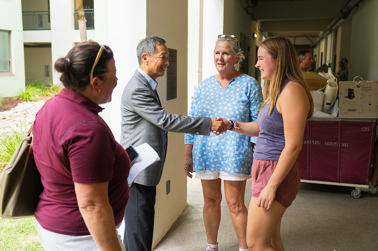 President Hsu shakes hands with students 