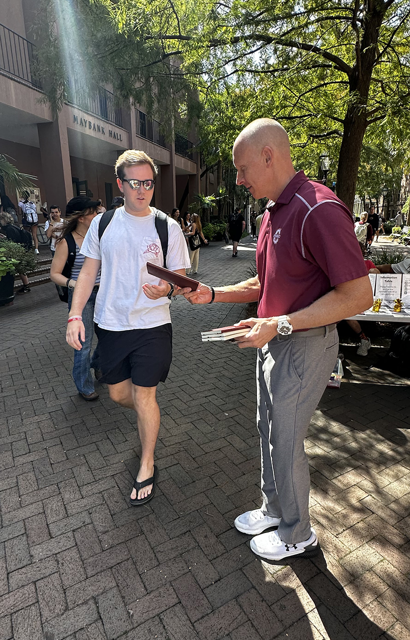 Coach hands out mini basketballs on campus 