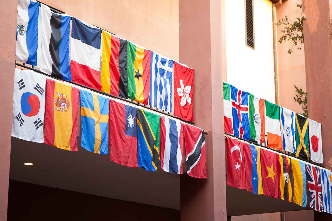 international flags hanging from pink building