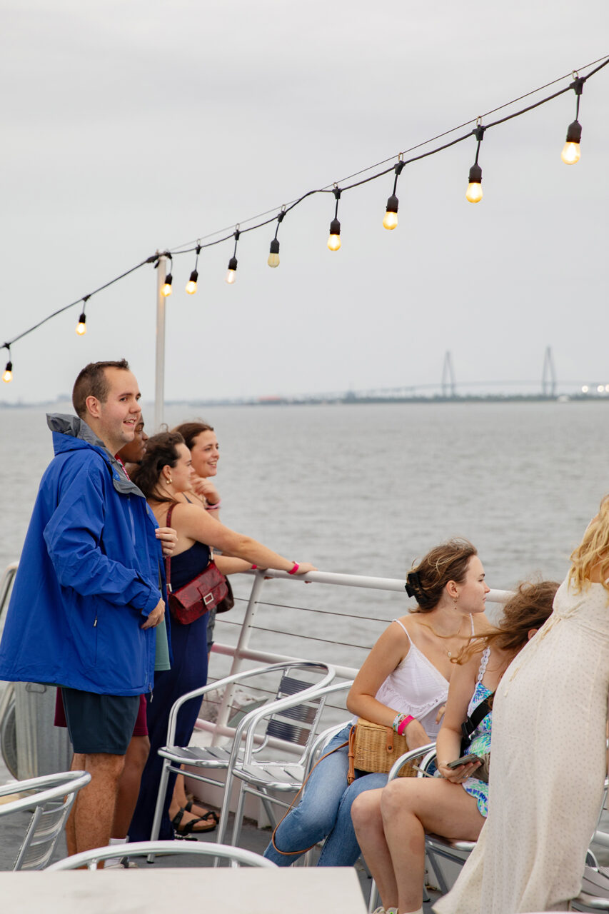 Students look at dolphin in the water at CAB Harbor Cruise event.