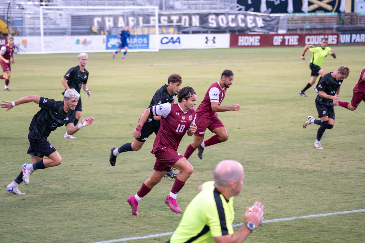 running down the field at the mens soccer game 