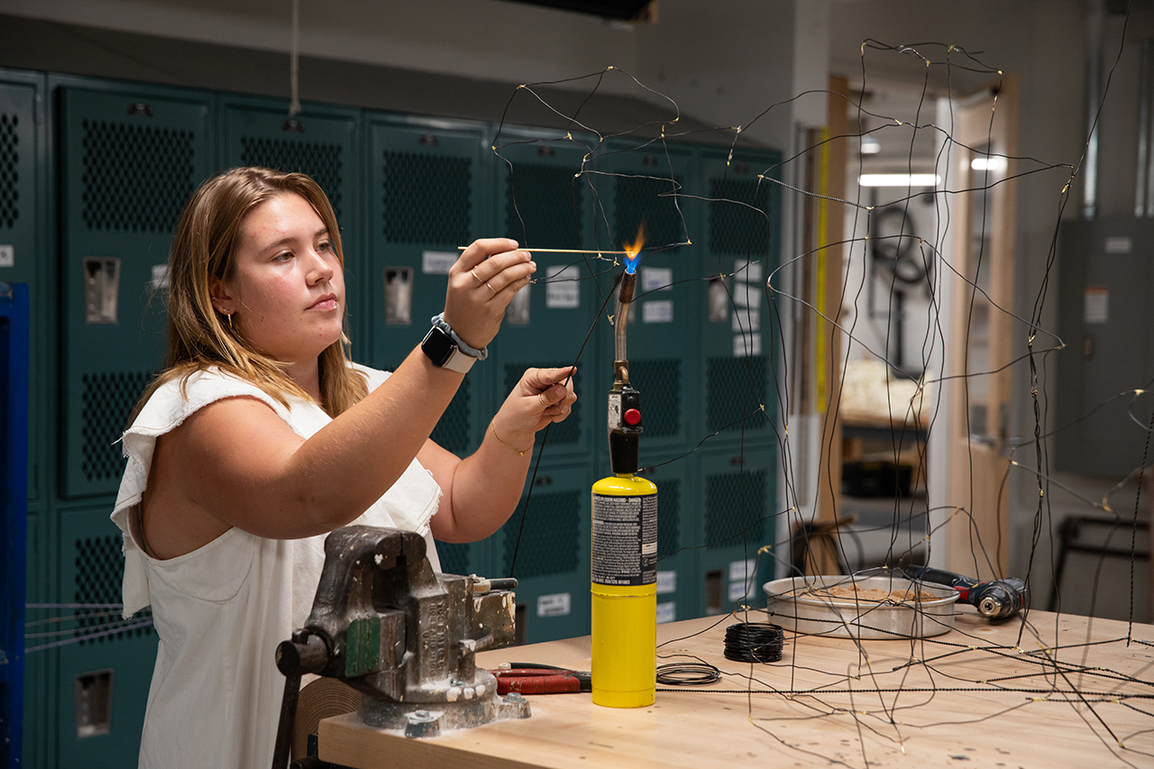 student works on art at opening