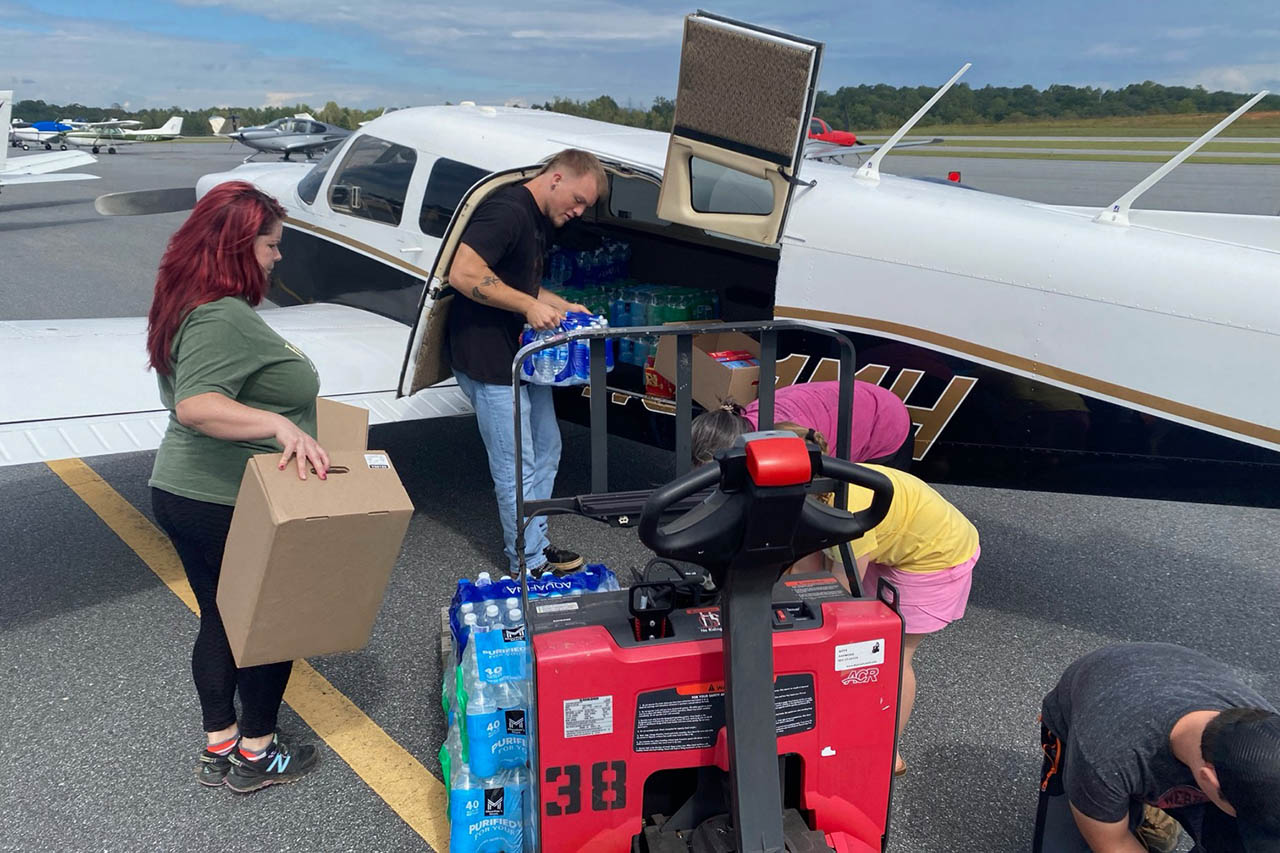 people loading things into tiny plane