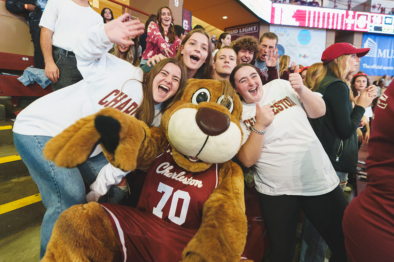 Clyde poses with students at the College of Charleston Men's Basketball Team home game