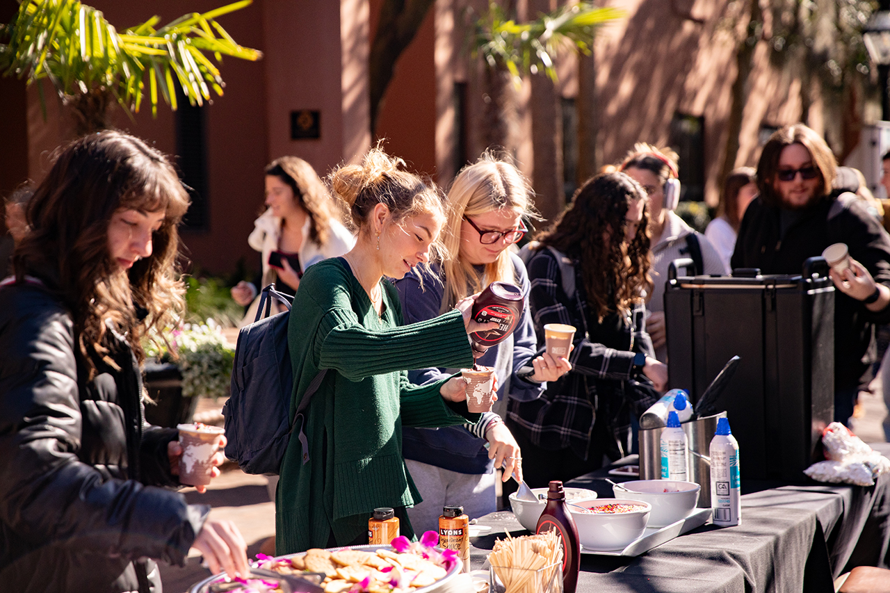 Students enjoy a free hot chocolate bar provided by the School of Humanities and Social Sciences in Cougar Mall.