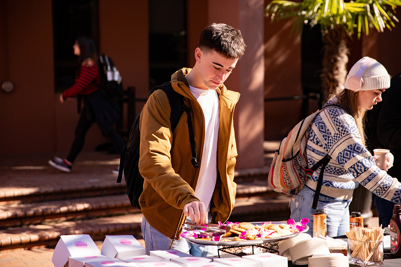 Students enjoy a free hot chocolate bar provided by the School of Humanities and Social Sciences in Cougar Mall.