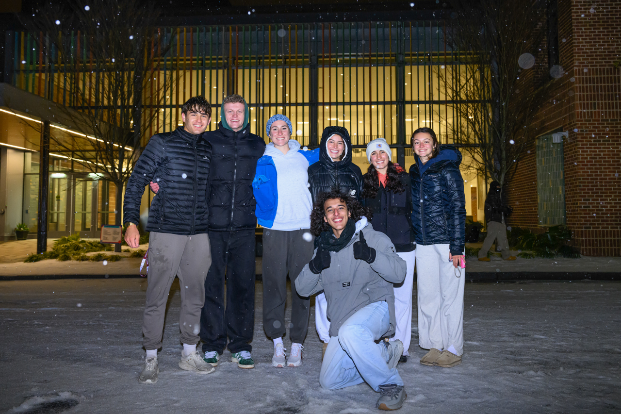 Students pose in front of Simmons Center in the snow 