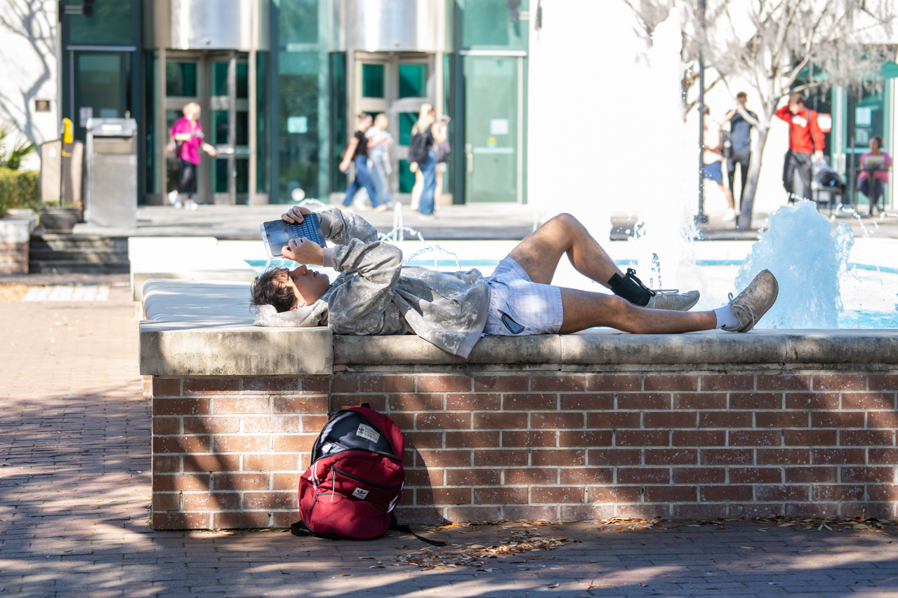 reading on the fountain ledge in Rivers Green 