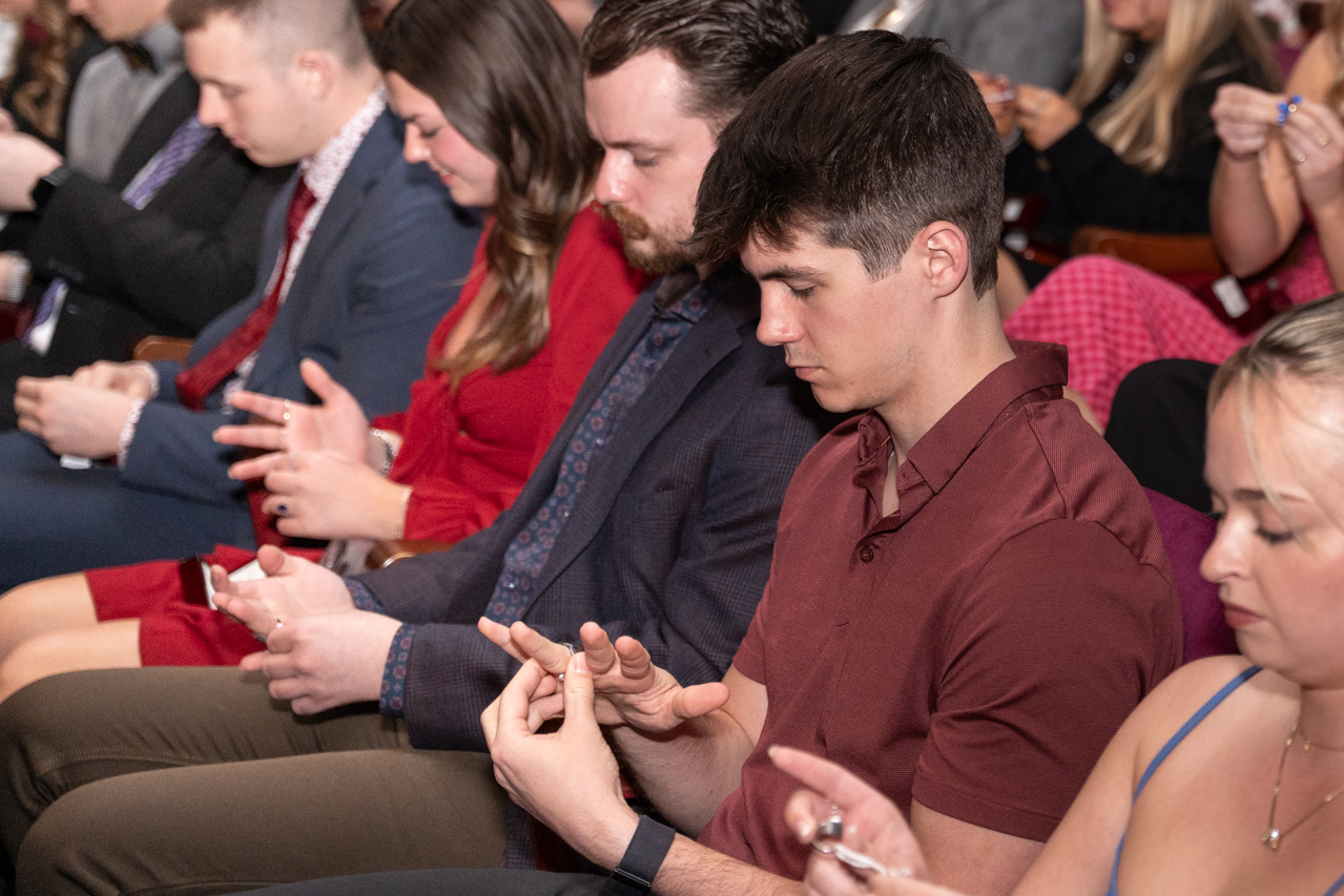 students put rings on together at the Sottile Theatre 