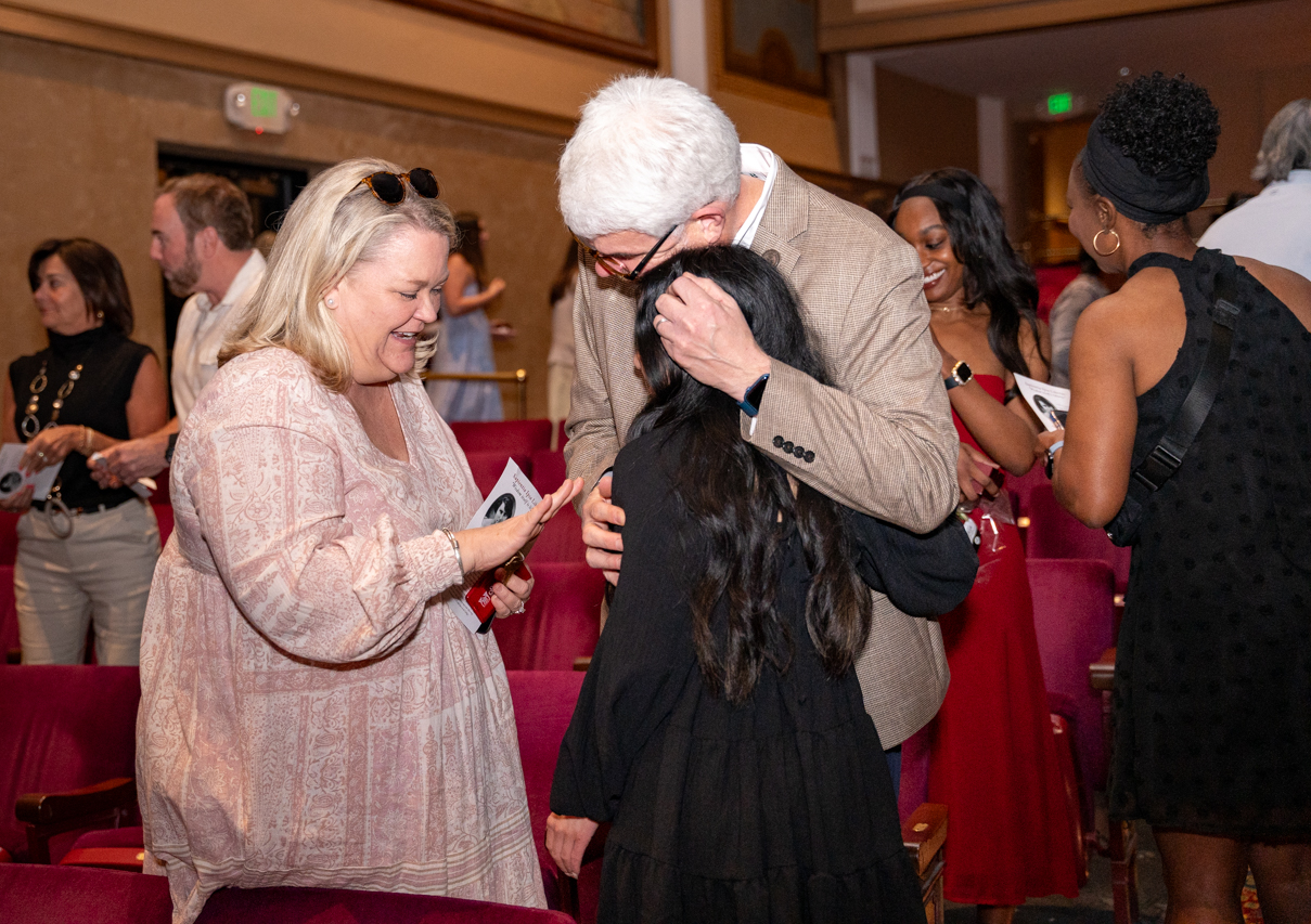 parents hug daughter at ring ceremony