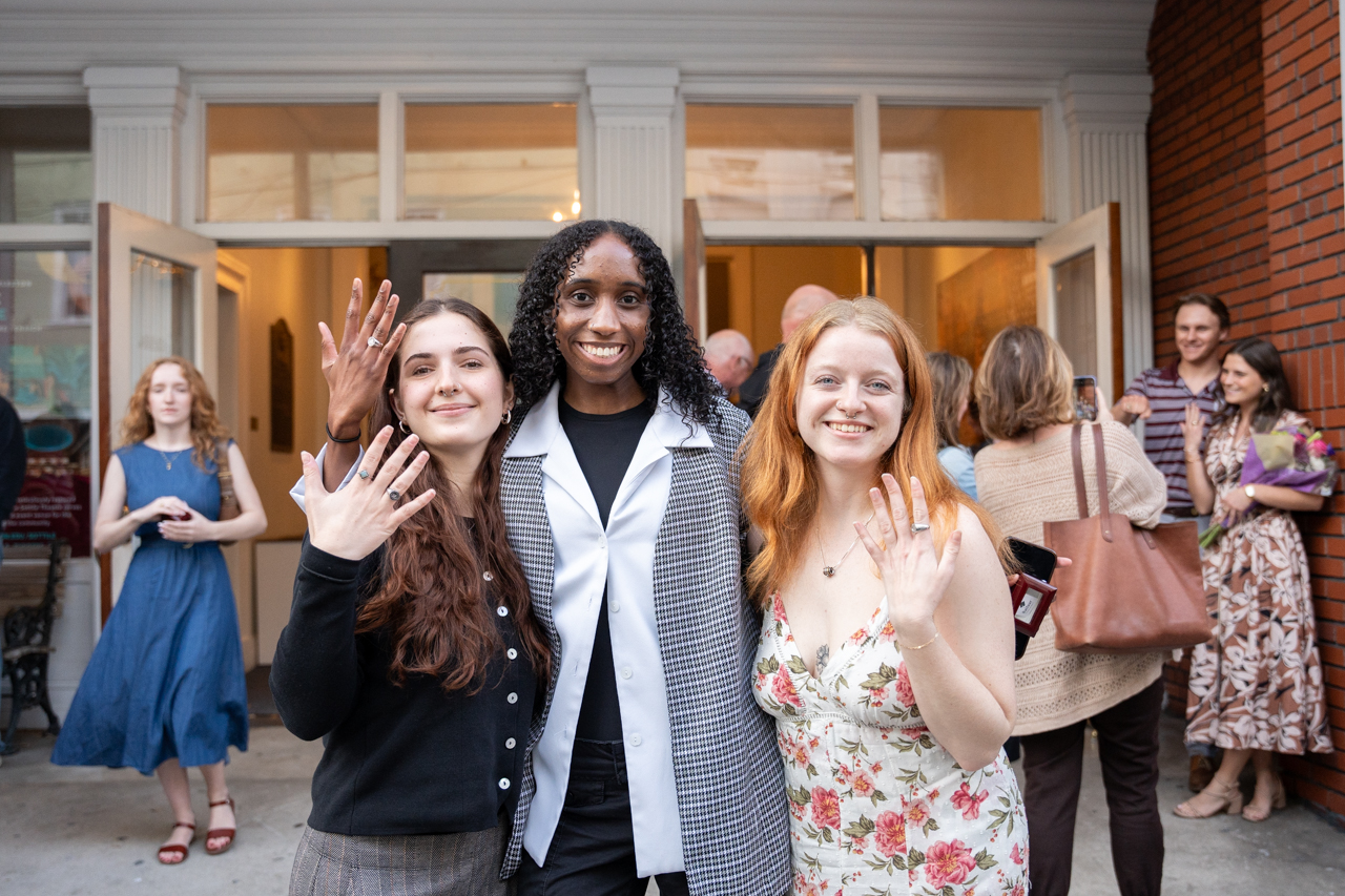 friends pose with rings after the ring ceremony 