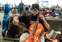 Zachary Butler practices his cello before boarding the plane for New York City.