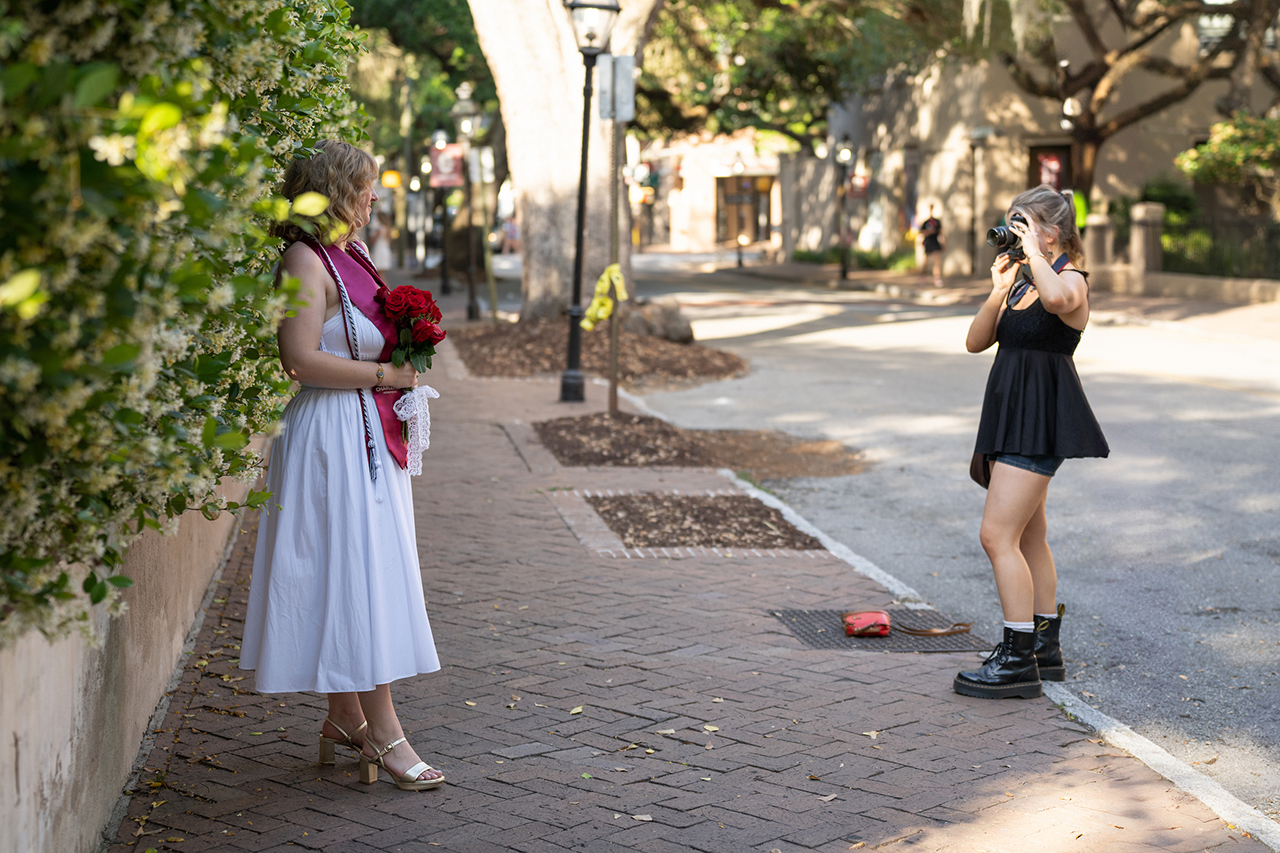 students pose for graduation photos on campus
