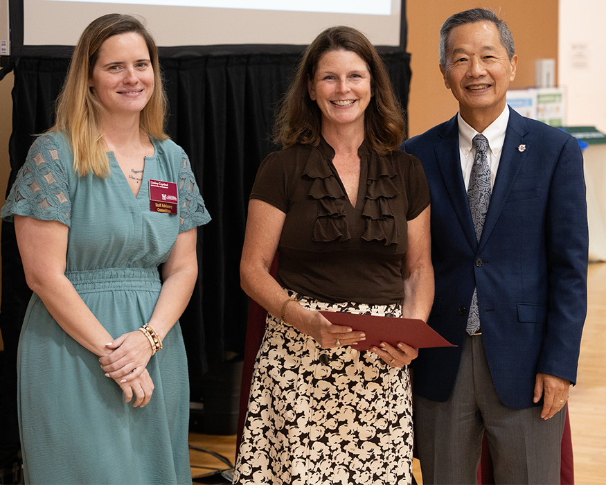 Michelle Futrell, winner of the Permanent Staff Emplouee of the Year, standing with President Andrew T. Hsu and SAC Chair Lindsey Copeland.