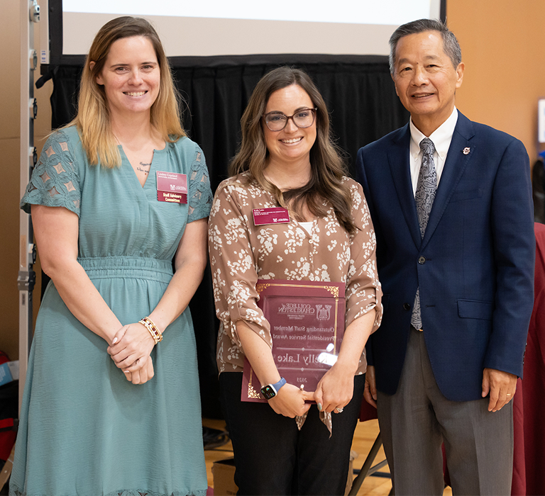 Kelly Lake, winner of the Outstanding Staff Member Presidential Service Award, standing with President Andrew T. Hsu and SAC Chair Lindsey Copeland.