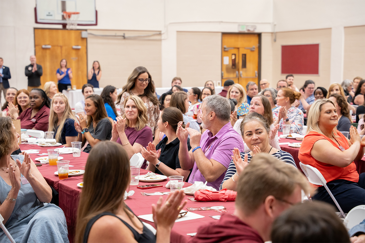 Staff clapping for one of the winners of the annual Staff Awards.