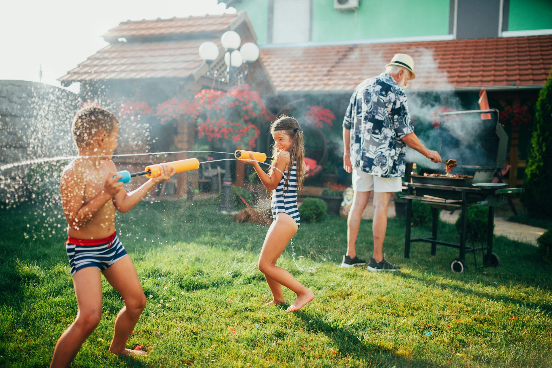 children playing with water guns at summer cookout