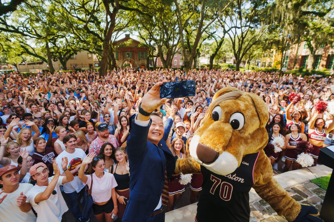 President Hsu Poses with students and Clyde at Convocation 