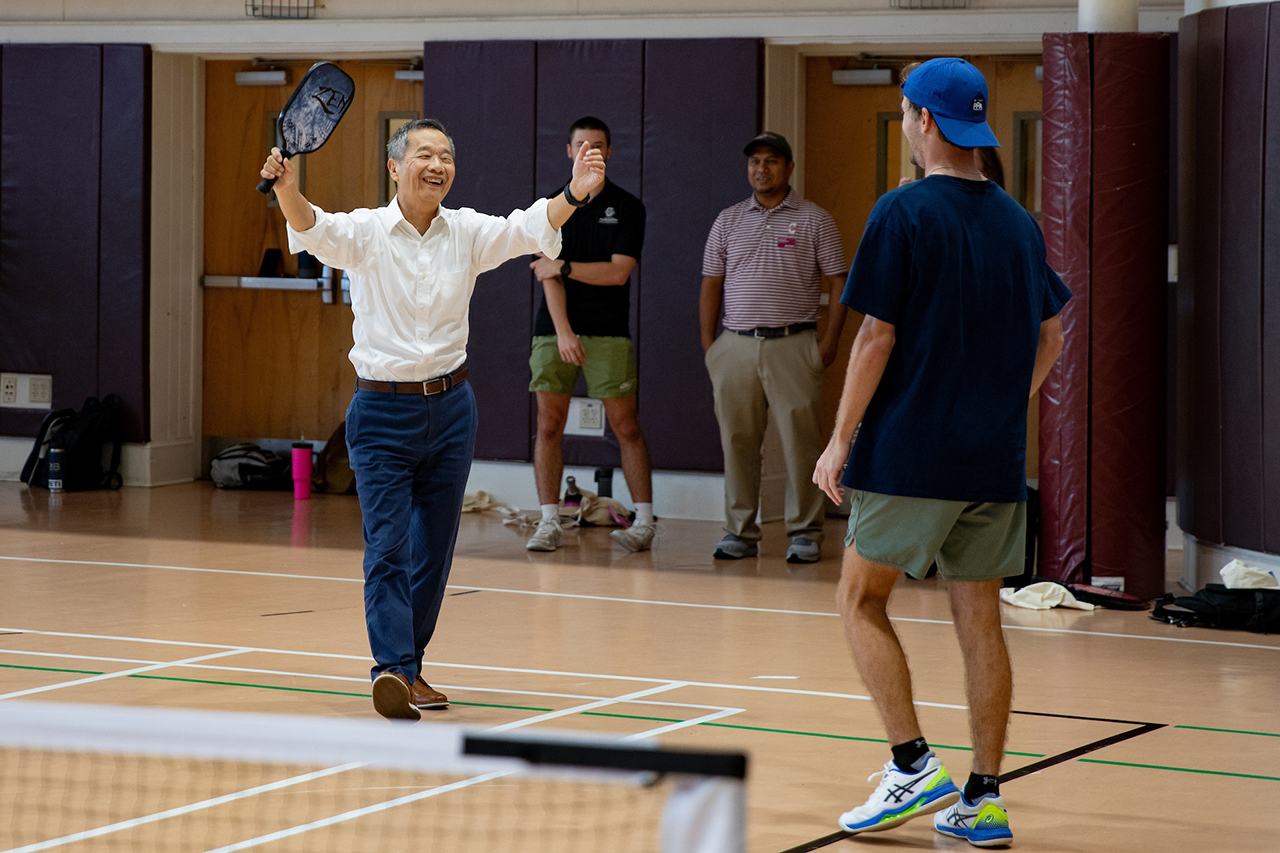 Students play a game of pickleball with President Hsu on the Johnson Center Gym courts.