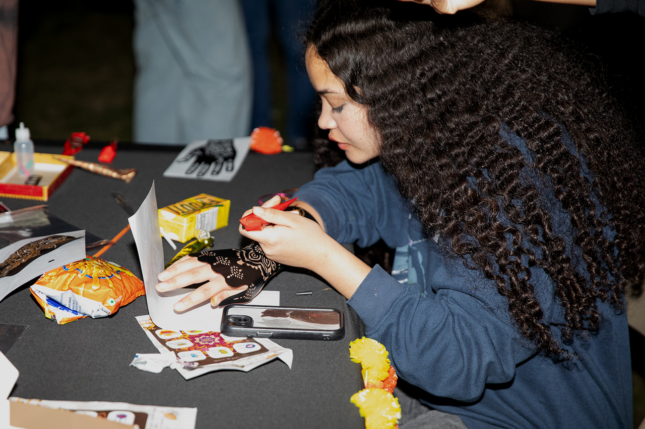 Students participate in a painting activity at the Diwali event in the Cistern.