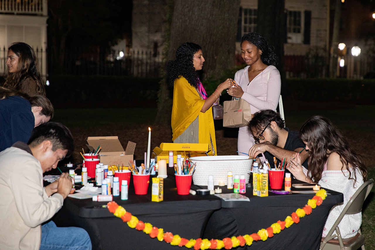 Students participate in a painting activity at the Diwali event in the Cistern.