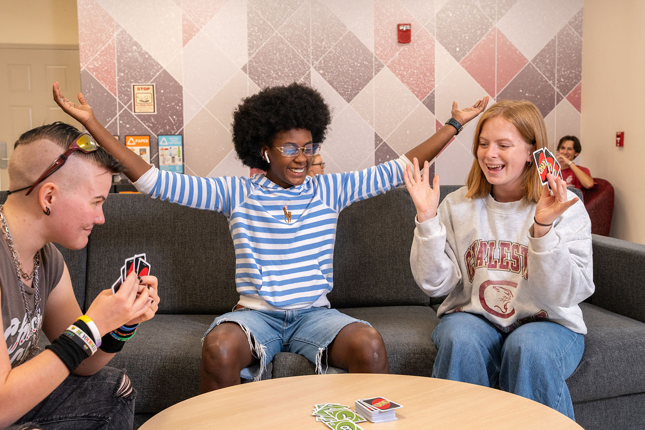 three students playing Uno
