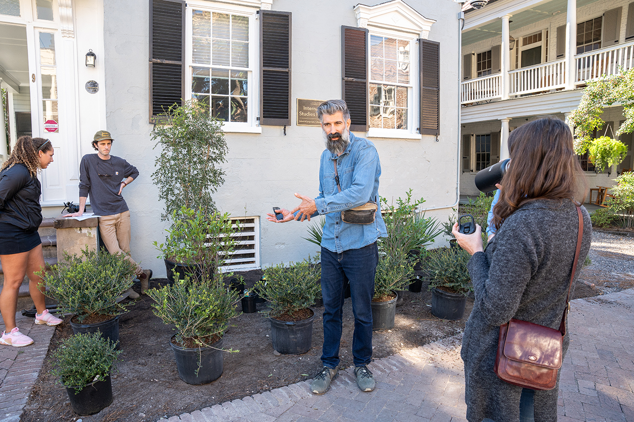 Man in front of white house speaks passionately to a crowd