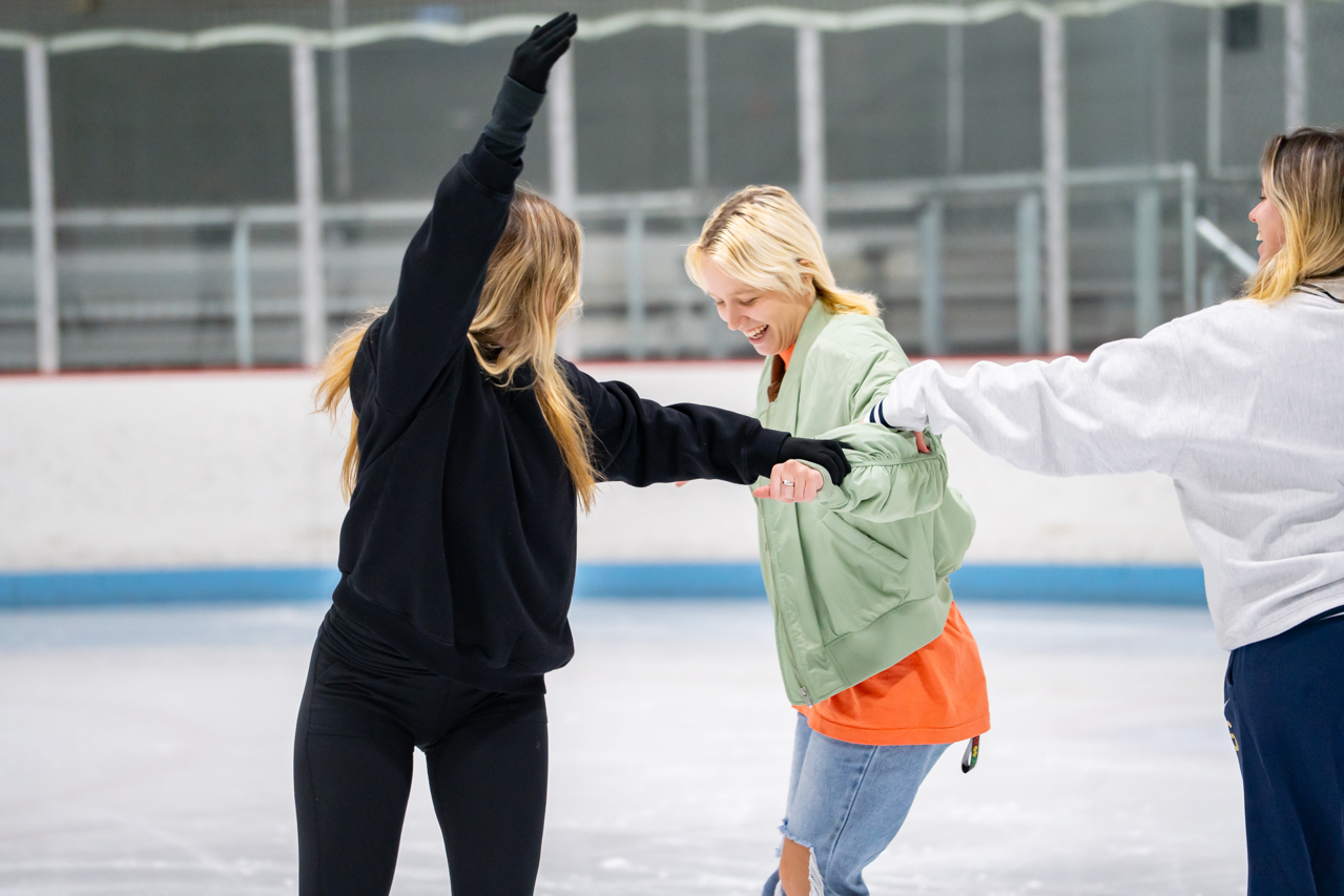 three female students circle each other laughing