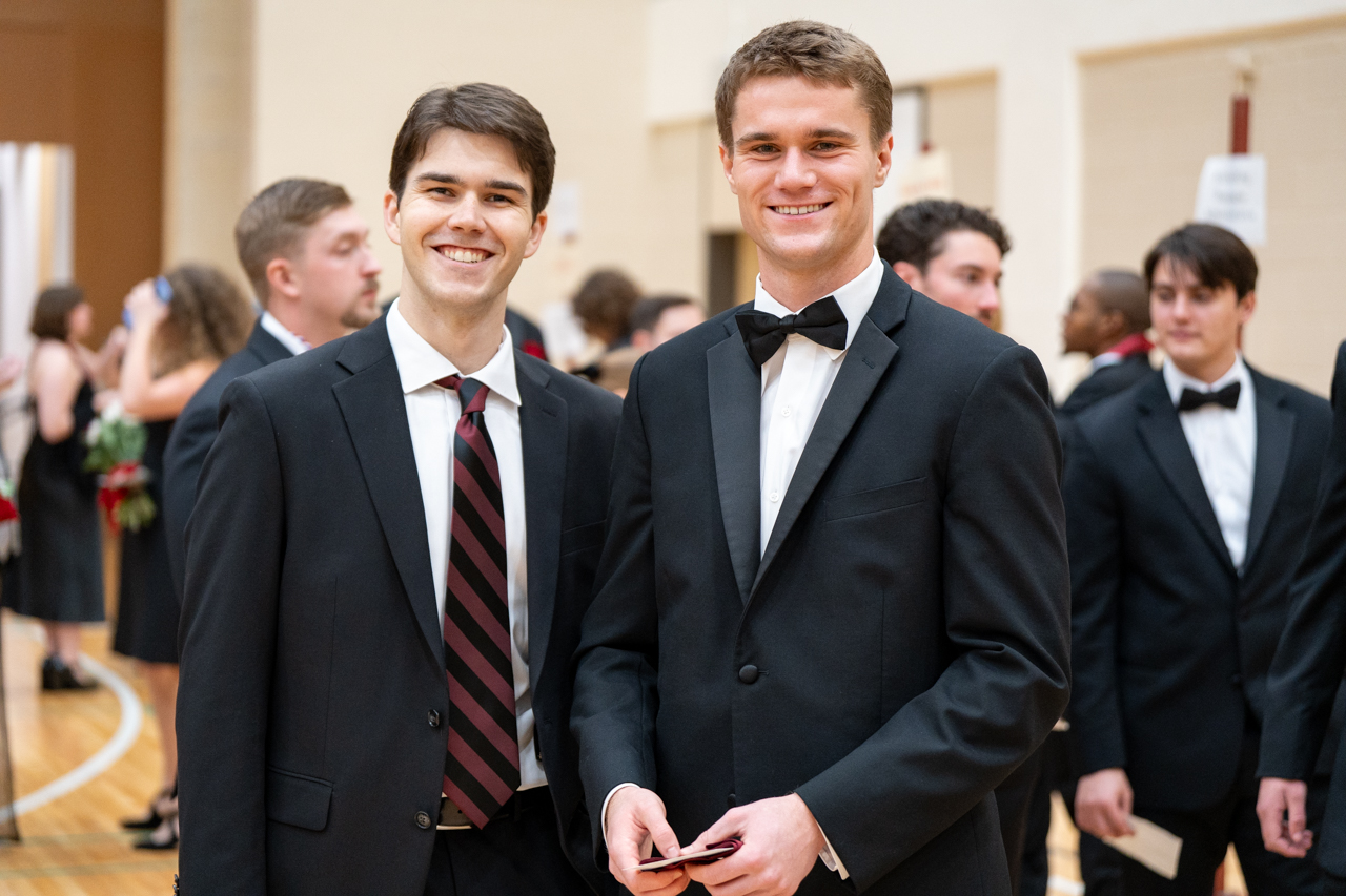 two male graduates smile for camera