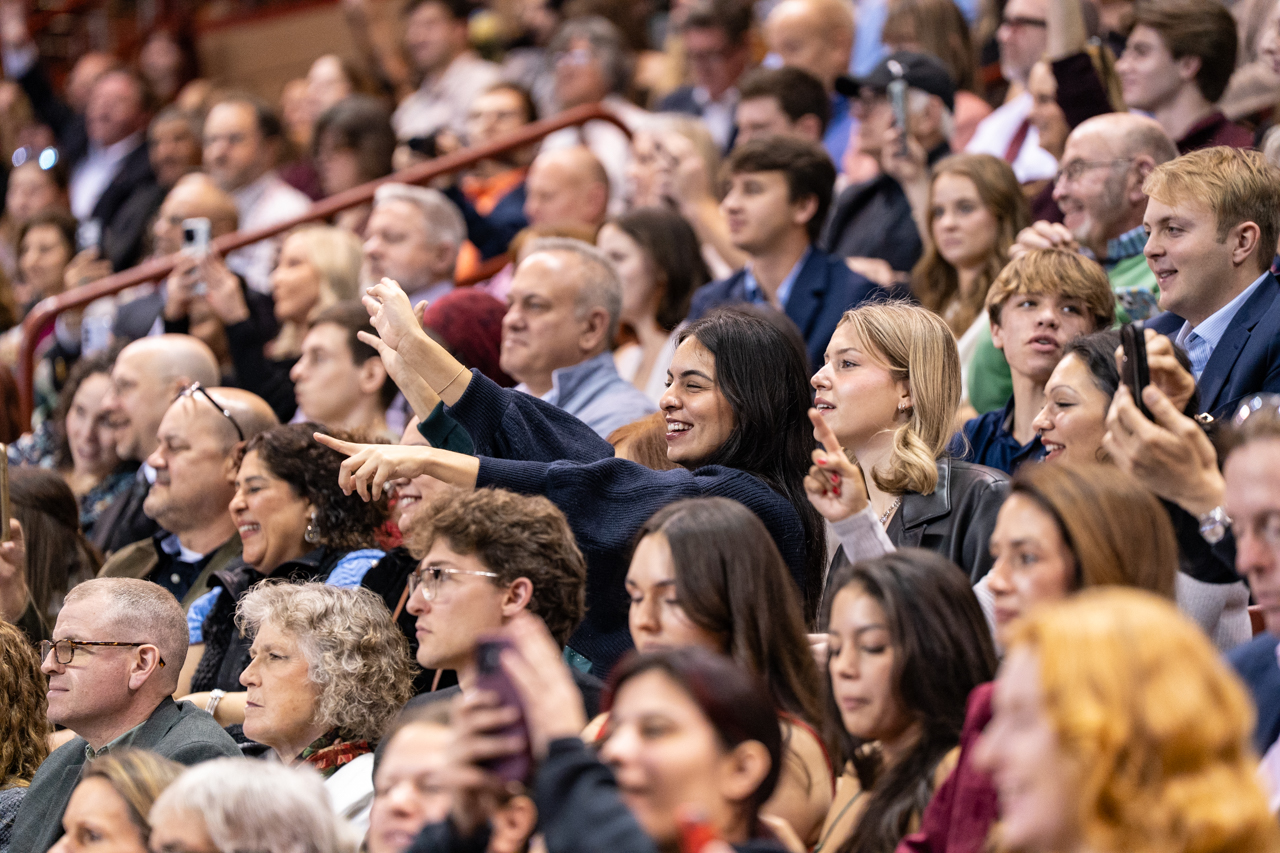 Crowd waves at their loved ones during graduation